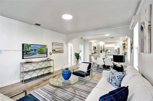 38 NW 47th Ter, Miami, FL 33127 - living room with arched walkways, ornamental molding, light wood-type flooring, and baseboards