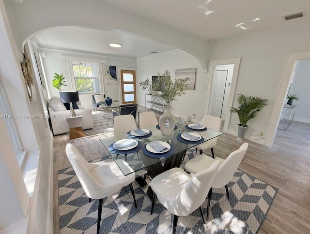 38 NW 47th Ter, Miami, FL 33127 - dining area with arched walkways, light wood-type flooring, and baseboards