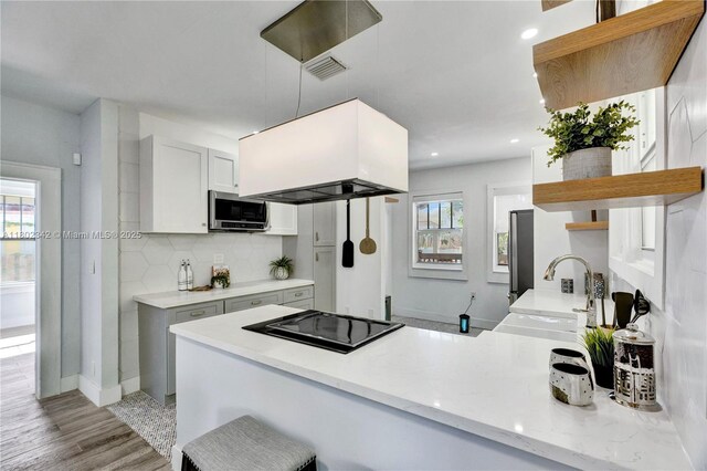 38 NW 47th Ter, Miami, FL 33127 - kitchen featuring open shelves, black electric cooktop, a sink, stainless steel microwave, and island range hood