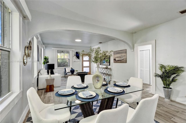 38 NW 47th Ter, Miami, FL 33127 - dining space with arched walkways, baseboards, and wood finished floors