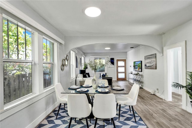 38 NW 47th Ter, Miami, FL 33127 - dining area featuring arched walkways, plenty of natural light, wood finished floors, and baseboards