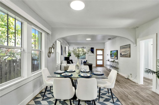 38 NW 47th Ter, Miami, FL 33127 - dining space with arched walkways, wood finished floors, and baseboards