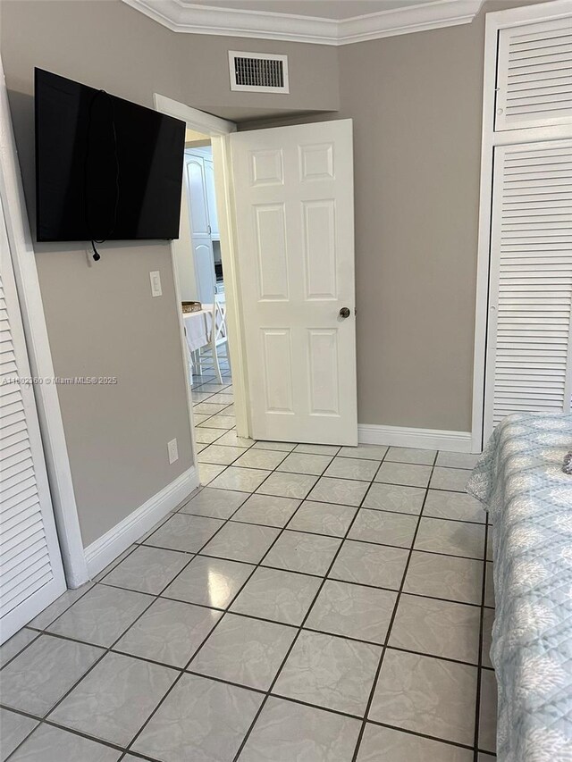 2600 S Ocean Dr Unit S113, Hollywood, FL 33019 - unfurnished bedroom featuring crown molding, light tile patterned floors, a closet, and baseboards