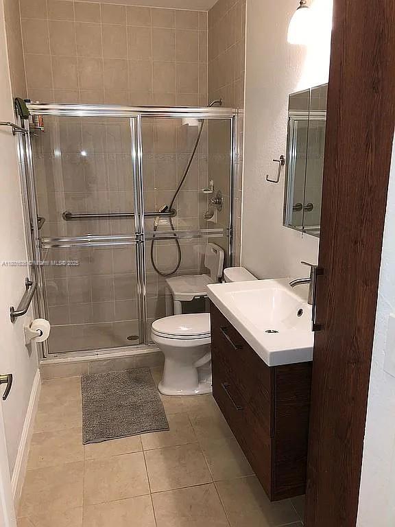 8753 SW 3rd Ln, Miami, FL 33174 - bathroom featuring vanity, toilet, a shower stall, tile patterned flooring, and baseboards