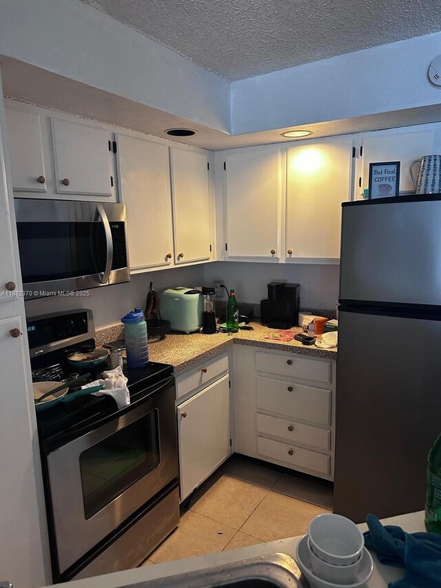 3310 N Pinewalk Dr N Unit 1814, Margate, FL 33063 - kitchen with appliances with stainless steel finishes, a textured ceiling, white cabinets, and light tile patterned flooring