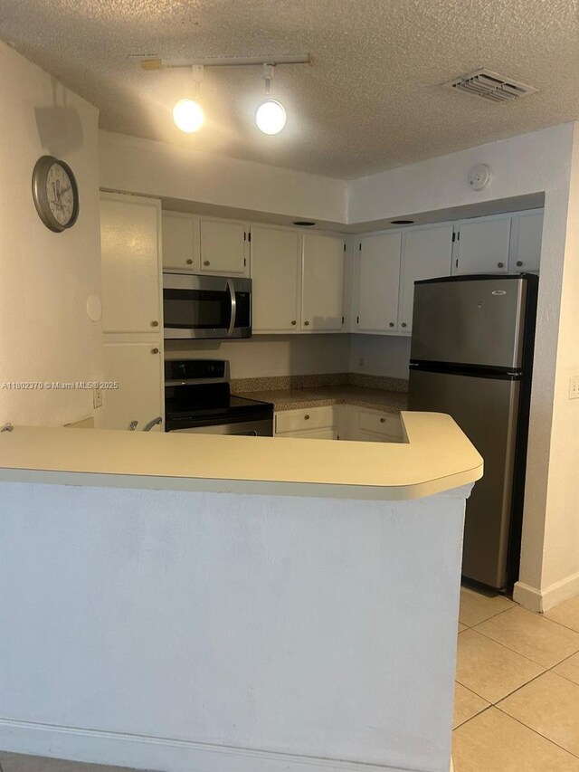 3310 N Pinewalk Dr N Unit 1814, Margate, FL 33063 - kitchen with stainless steel appliances, light tile patterned floors, a textured ceiling, a peninsula, and track lighting