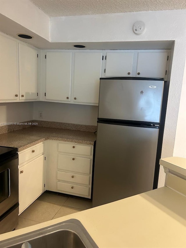 3310 N Pinewalk Dr N Unit 1814, Margate, FL 33063 - kitchen with stainless steel appliances, light tile patterned floors, white cabinets, and a textured ceiling