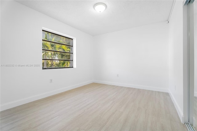 1661 SW 3rd St Unit 8, Miami, FL 33135 - spare room featuring light wood-type flooring, baseboards, and a textured ceiling