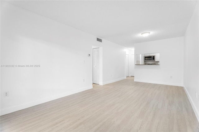 1661 SW 3rd St Unit 8, Miami, FL 33135 - unfurnished living room with light wood-style flooring and baseboards