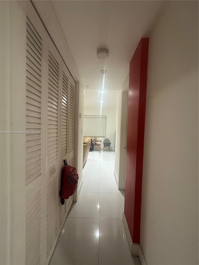hall featuring baseboards and tile patterned flooring