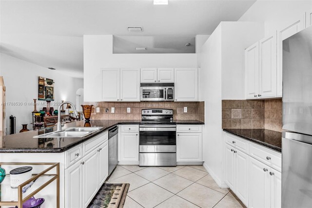 2819 Augusta Ln, Homestead, FL 33035 - kitchen featuring stainless steel appliances, a sink, a peninsula, light tile patterned flooring, and white cabinetry