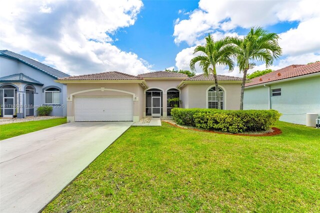 2819 Augusta Ln, Homestead, FL 33035 - mediterranean / spanish house featuring a tiled roof, an attached garage, a front lawn, and concrete driveway