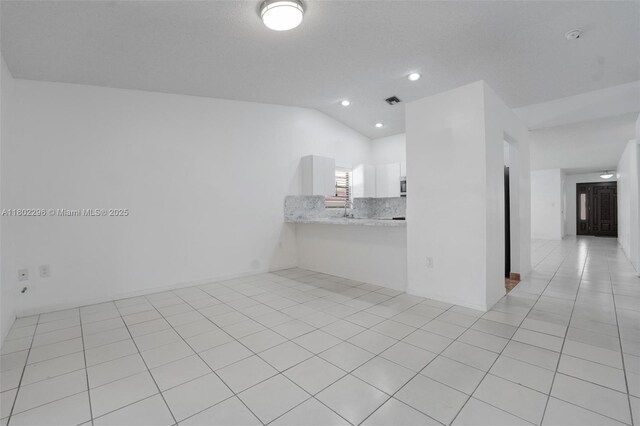 14431 SW 111th Ter, Miami, FL 33186 - unfurnished living room with lofted ceiling, light tile patterned floors, and recessed lighting