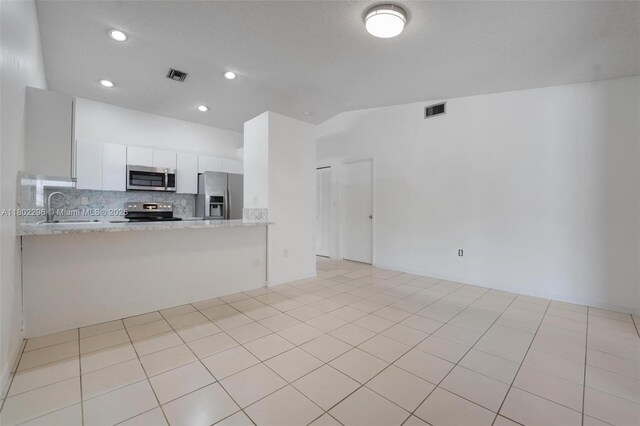 14431 SW 111th Ter, Miami, FL 33186 - kitchen featuring appliances with stainless steel finishes, a sink, tasteful backsplash, white cabinets, and a peninsula