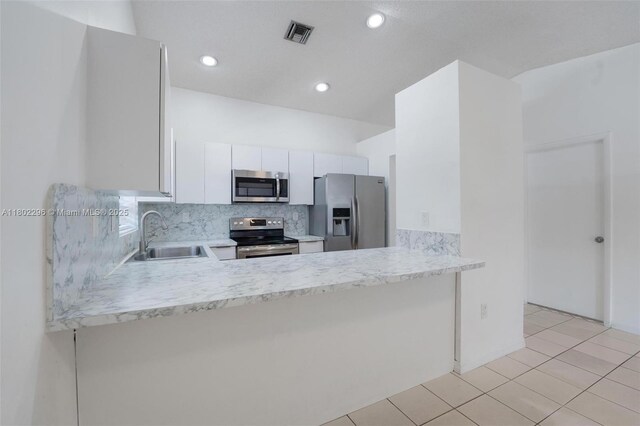 14431 SW 111th Ter, Miami, FL 33186 - kitchen with stainless steel appliances, a sink, light countertops, decorative backsplash, and a peninsula