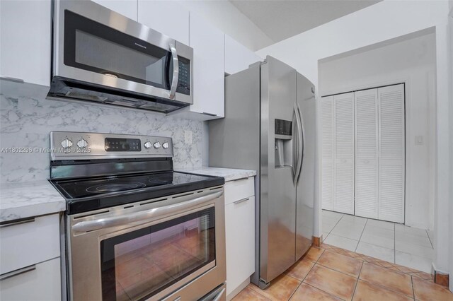 14431 SW 111th Ter, Miami, FL 33186 - kitchen featuring appliances with stainless steel finishes, white cabinets, backsplash, modern cabinets, and light tile patterned floors