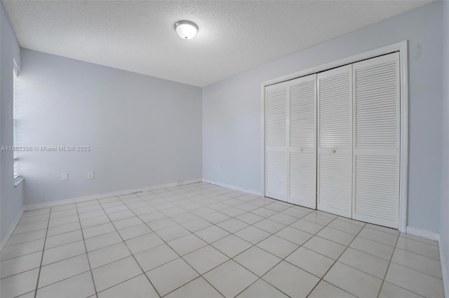 14431 SW 111th Ter, Miami, FL 33186 - unfurnished bedroom with a textured ceiling, a closet, and baseboards