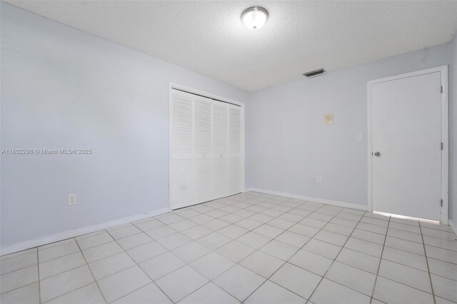 14431 SW 111th Ter, Miami, FL 33186 - unfurnished bedroom featuring a textured ceiling, a closet, and baseboards
