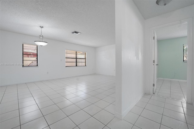 14431 SW 111th Ter, Miami, FL 33186 - empty room featuring light tile patterned floors, healthy amount of natural light, a textured ceiling, and baseboards