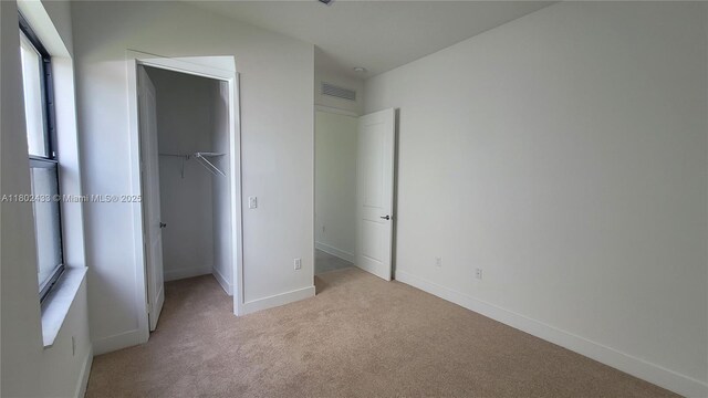 4578 SW 174th Ave, Miramar, FL 33029 - unfurnished bedroom featuring light carpet, a walk in closet, a closet, and baseboards