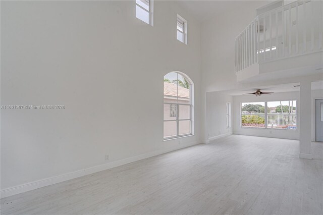 6381 Willoughby Cir, Lake Worth, FL 33463 - unfurnished living room with wood finished floors, baseboards, a high ceiling, and ceiling fan