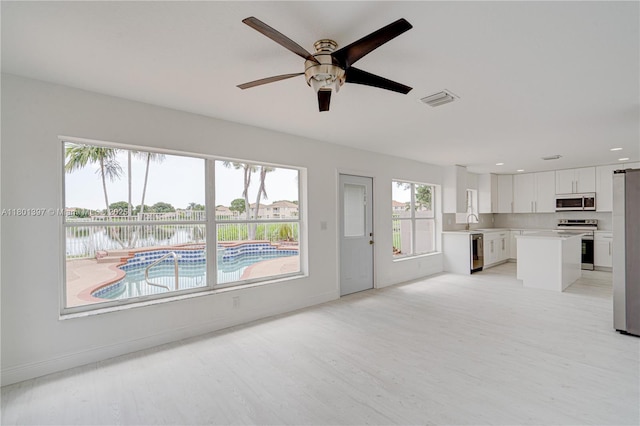 6381 Willoughby Cir, Lake Worth, FL 33463 - unfurnished living room featuring ceiling fan, baseboards, light wood finished floors, a sink, and recessed lighting