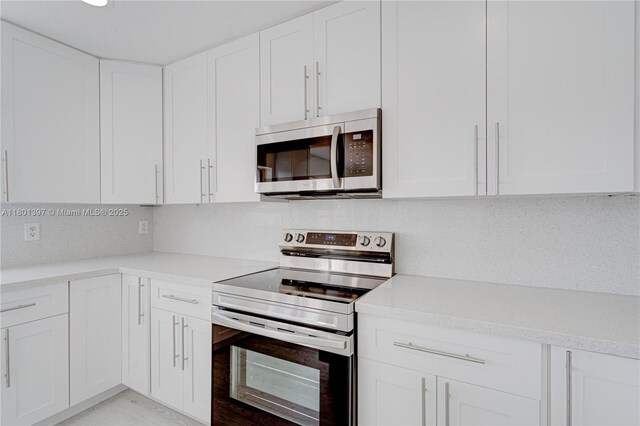 6381 Willoughby Cir, Lake Worth, FL 33463 - kitchen featuring appliances with stainless steel finishes, light countertops, and white cabinets