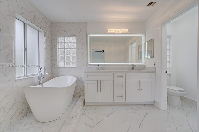 6381 Willoughby Cir, Lake Worth, FL 33463 - bathroom featuring marble finish floors, a freestanding tub, toilet, and double vanity