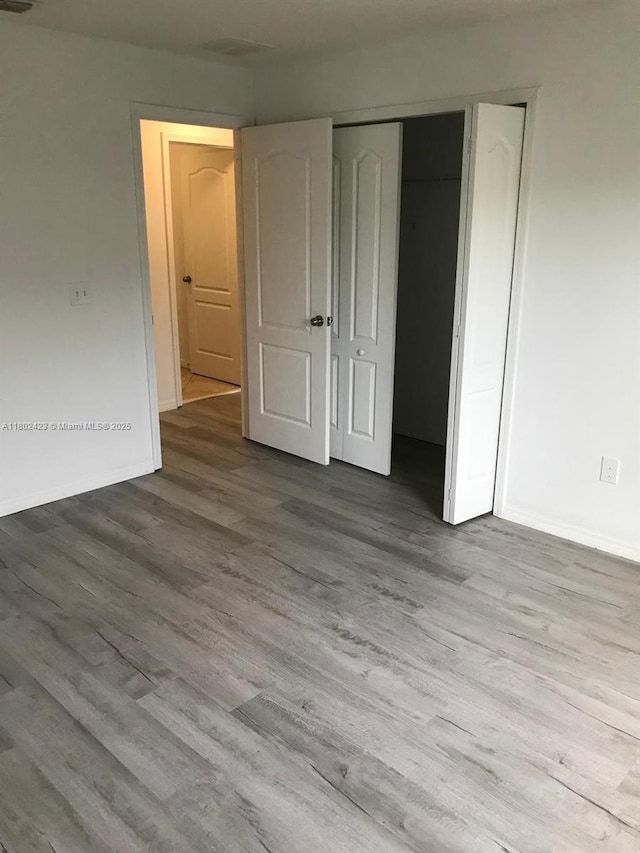 3319 Rodrick Cir, Orlando, FL 32824 - unfurnished bedroom featuring wood finished floors, baseboards, and a closet