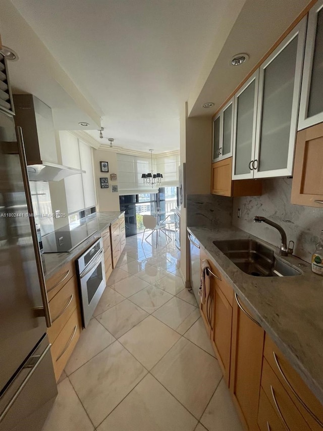 kitchen featuring stainless steel appliances, a sink, tasteful backsplash, glass insert cabinets, and stone counters