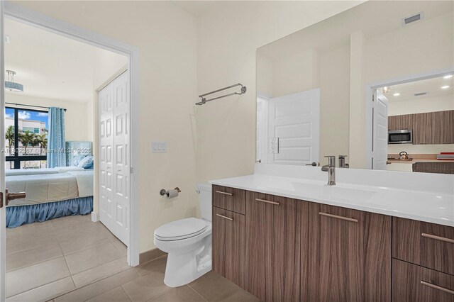 8301 NW 41st St Unit B-303, Doral, FL 33166 - bathroom with connected bathroom, toilet, tile patterned floors, vanity, and baseboards