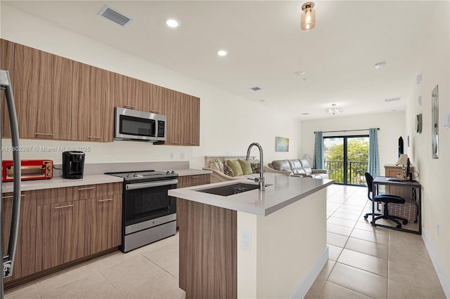 8301 NW 41st St Unit B-303, Doral, FL 33166 - kitchen featuring appliances with stainless steel finishes, a sink, open floor plan, light tile patterned floors, and light countertops