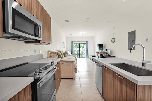 8301 NW 41st St Unit B-303, Doral, FL 33166 - kitchen featuring stainless steel appliances, a sink, open floor plan, light countertops, and light tile patterned floors