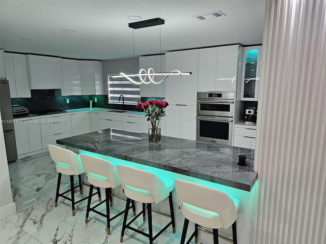 19110 NW 88th Ct, Hialeah, FL 33018 - kitchen featuring light marble finish flooring, modern cabinets, and a kitchen bar