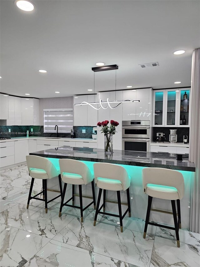 19110 NW 88th Ct, Hialeah, FL 33018 - kitchen featuring modern cabinets, double oven, white cabinetry, a breakfast bar, and recessed lighting