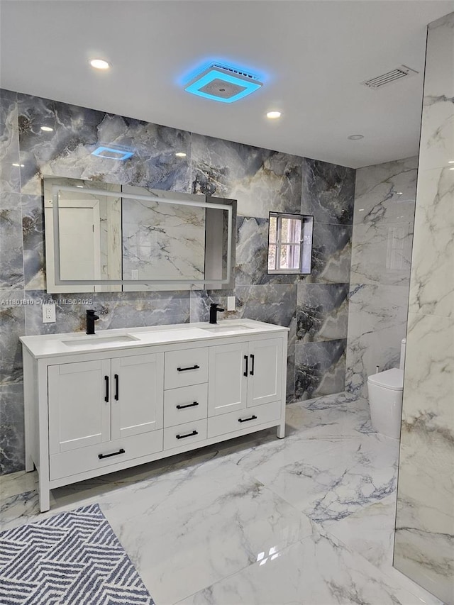 19110 NW 88th Ct, Hialeah, FL 33018 - full bathroom with marble tiled floors, double vanity, toilet, recessed lighting, and tile walls