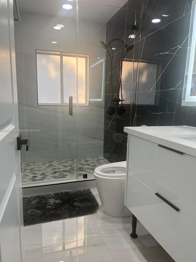 19110 NW 88th Ct, Hialeah, FL 33018 - full bathroom featuring a stall shower, tile walls, marble finish flooring, toilet, and vanity