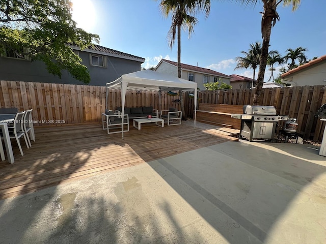 19110 NW 88th Ct, Hialeah, FL 33018 - wooden terrace with a gazebo, a grill, outdoor lounge area, and a fenced backyard