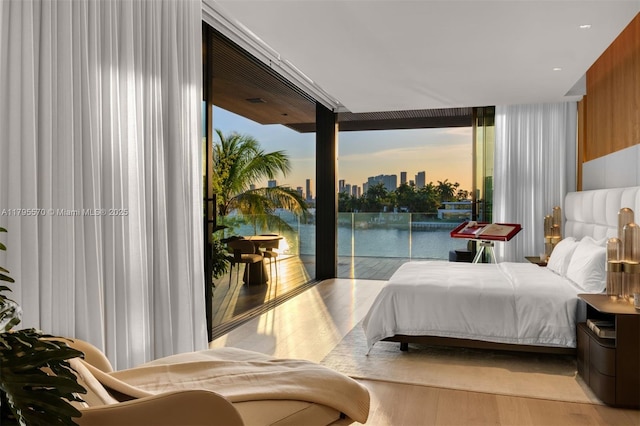 220 W Dilido Dr, Miami Beach, FL 33139 - bedroom with access to exterior, wood finished floors, a skyline view, and floor to ceiling windows