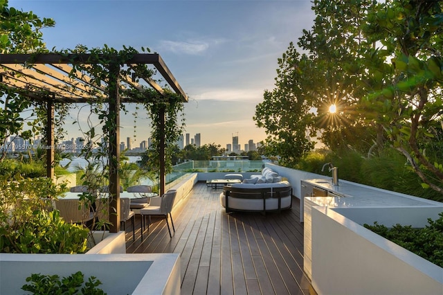 220 W Dilido Dr, Miami Beach, FL 33139 - deck at dusk with outdoor dining area, a sink, and a city view