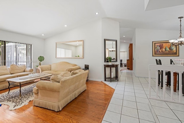 living room featuring vaulted ceiling, a chandelier, light tile patterned floors, recessed lighting, and baseboards