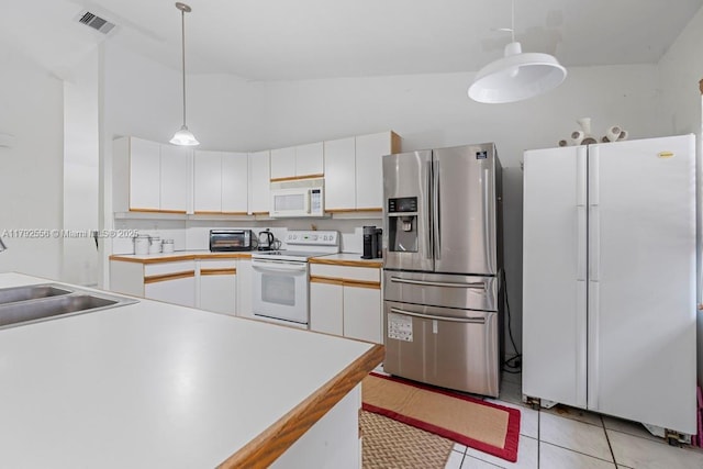 kitchen with white appliances, a sink, white cabinetry, light countertops, and light tile patterned flooring