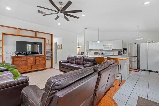 living room featuring a ceiling fan, vaulted ceiling, and recessed lighting
