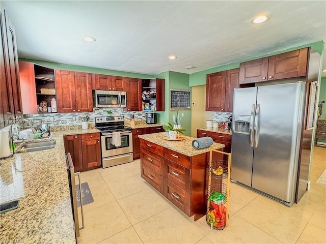 4002 Cascade Ln, La Belle, FL 33935 - kitchen featuring open shelves, appliances with stainless steel finishes, backsplash, a kitchen island, and light stone countertops