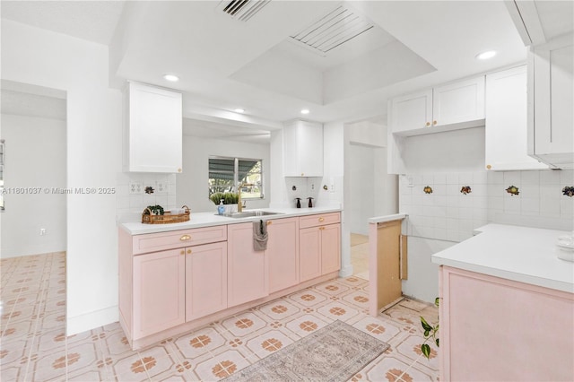 5706 NW 81st Ave, Tamarac, FL 33321 - kitchen with a sink, a raised ceiling, recessed lighting, light countertops, and white cabinetry