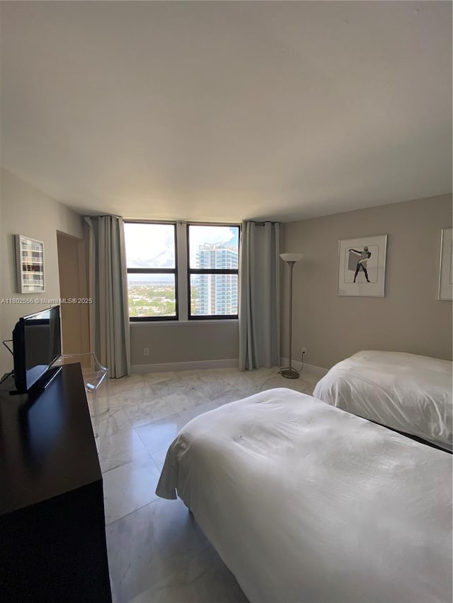 bedroom with baseboards and light marble finish flooring