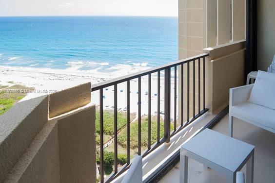balcony with view of water and beach