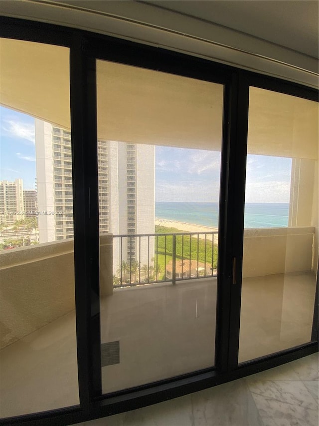 doorway to outside with plenty of natural light, a water view, and marble finish flooring