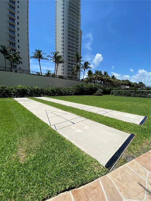 surrounding community featuring shuffleboard and a lawn