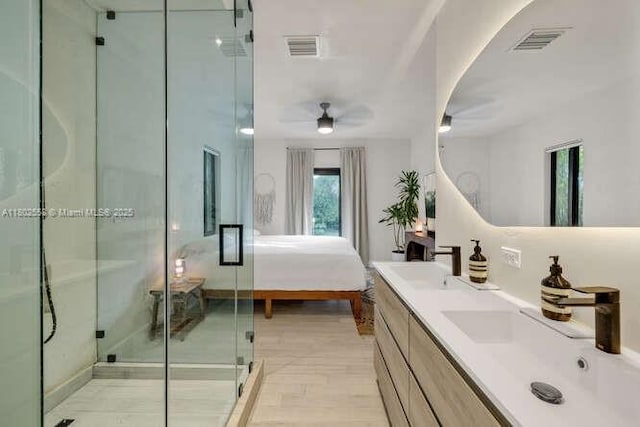 4228 NW 3rd Ave, Miami, FL 33127 - full bathroom featuring double vanity, a stall shower, wood finished floors, a ceiling fan, and ensuite bathroom